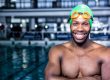 Fit swimmer standing with arms crossed in swimming pool